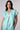 Model wearing Nicilian's Aura Blouse in Opal — a regenerative silk top with cap sleeves, front pleat, and V-neckline.
