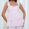 The Cascade Blouse in light pink, a silk peplum top with a sweetheart bodice and tiered georgette below.