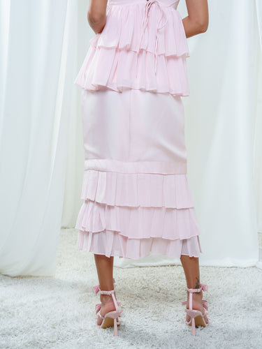 Back view of the Cascade Skirt in light pink, running smooth from the top edge to the ruffled hem.
