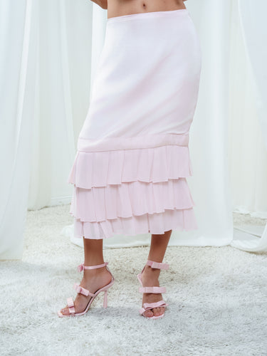The Cascade Skirt in light pink, a straight silk midi skirt with tiered georgette ruffles at the hem.
