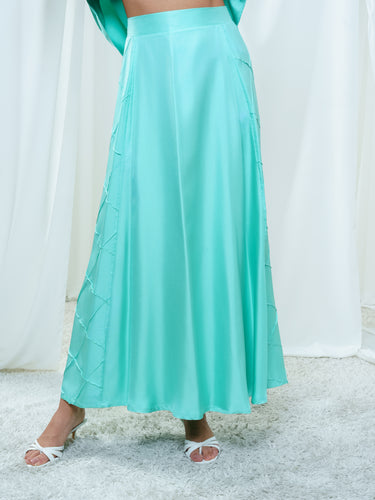 The Dusk Skirt in turquoise, a floor-length gored silk twill skirt with diamond-seamed panels.