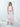 The Float Skirt and Solana Halter in light pink worn as a set, a cropped halter above a tiered silk skirt.
