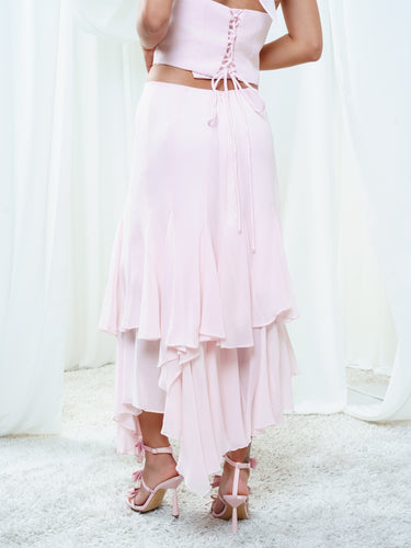 Back view of the Float Skirt in light pink, smooth through the hip above the layered georgette hem.