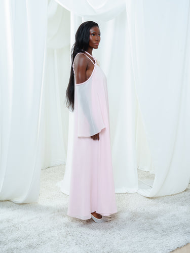 Side view of the Vesper Dress in light pink, showing the georgette sleeve falling free of the open shoulder.